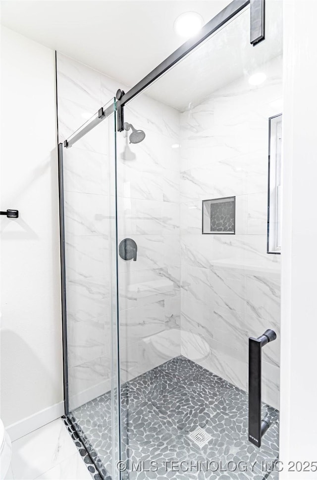 bathroom featuring a shower with door