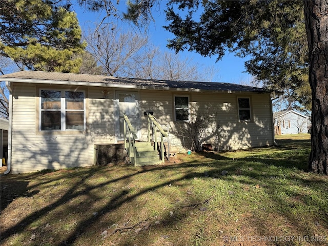 rear view of property with a lawn