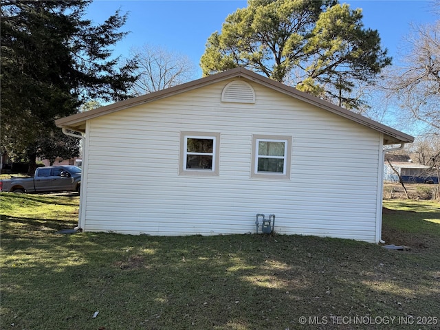 view of side of home with a lawn