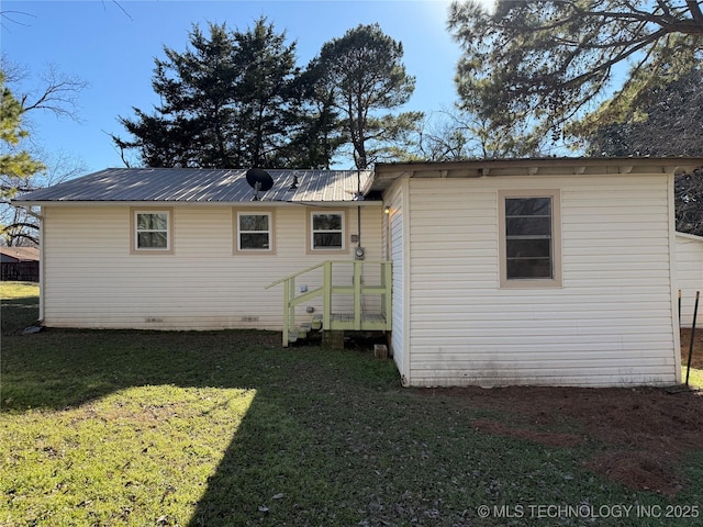 rear view of house featuring a yard