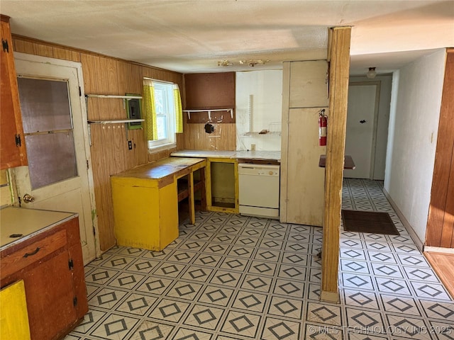 kitchen with white dishwasher and wood walls