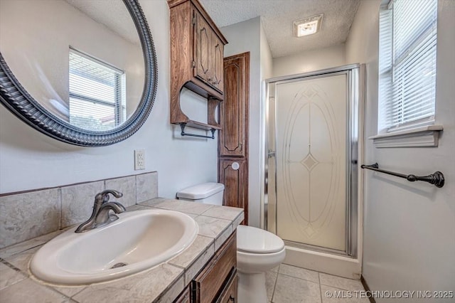 bathroom featuring tile patterned flooring, vanity, a textured ceiling, a shower with shower door, and toilet