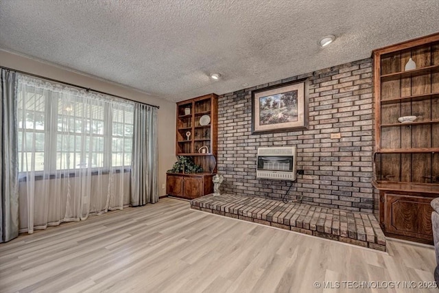 unfurnished living room with a fireplace, light hardwood / wood-style floors, and a textured ceiling