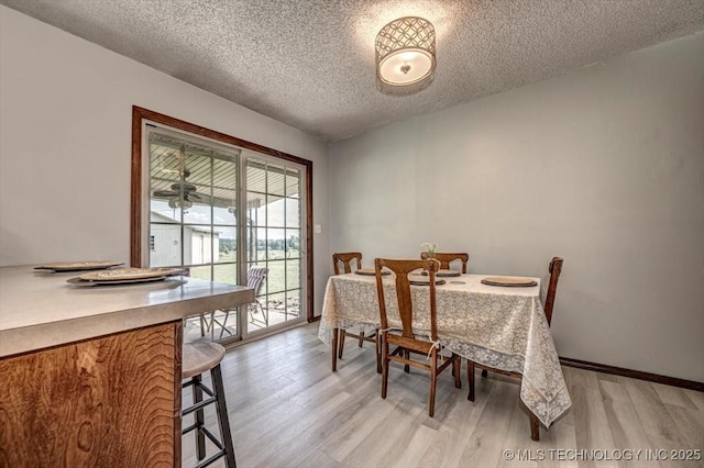 dining area featuring a textured ceiling and light hardwood / wood-style floors