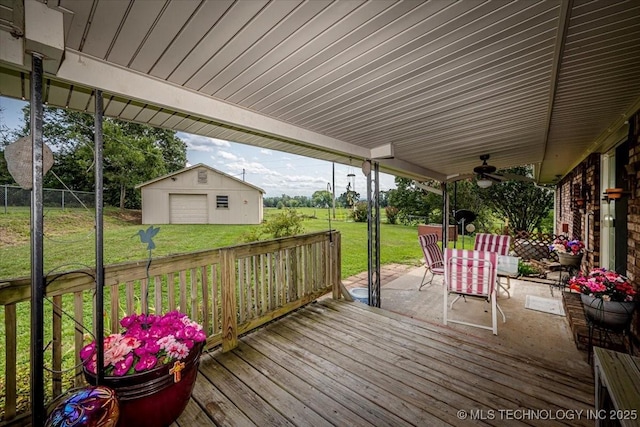 wooden terrace with a lawn, ceiling fan, a patio, a garage, and an outdoor structure