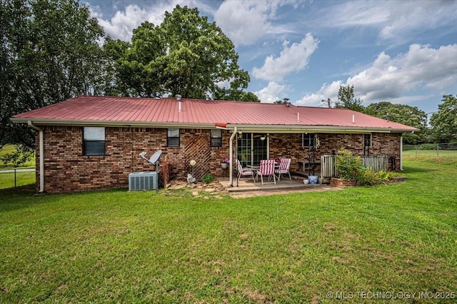 rear view of house with a yard, central AC, and a patio area