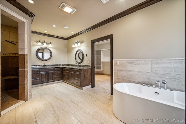 bathroom with independent shower and bath, ornamental molding, tile walls, and vanity