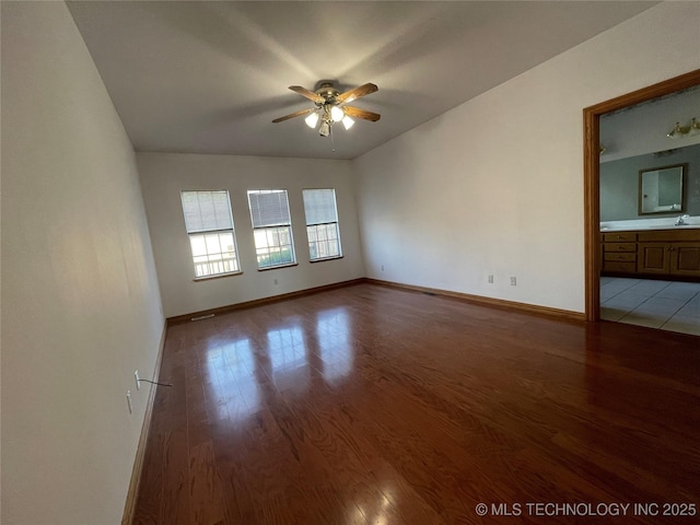 spare room featuring ceiling fan, light wood-style flooring, and baseboards