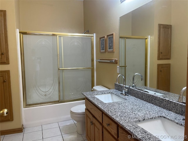 bathroom with double vanity, shower / bath combination with glass door, a sink, and tile patterned floors