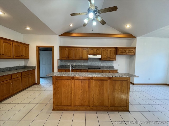 kitchen featuring light tile patterned floors, a center island with sink, black electric stovetop, and brown cabinetry