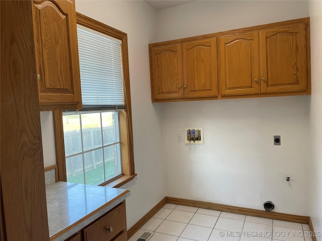 washroom with light tile patterned floors, gas dryer hookup, washer hookup, cabinet space, and electric dryer hookup