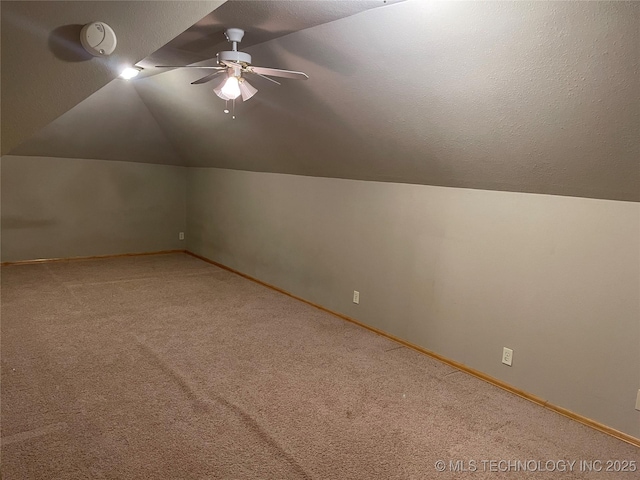 bonus room featuring carpet floors, a ceiling fan, vaulted ceiling, a textured ceiling, and baseboards