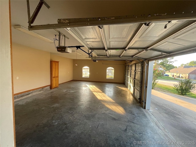 garage with baseboards and a garage door opener