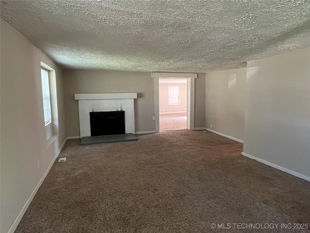 unfurnished living room with dark colored carpet and a textured ceiling