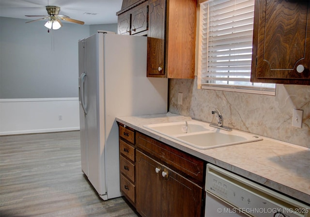 kitchen with sink, dark brown cabinetry, ceiling fan, white appliances, and light hardwood / wood-style flooring