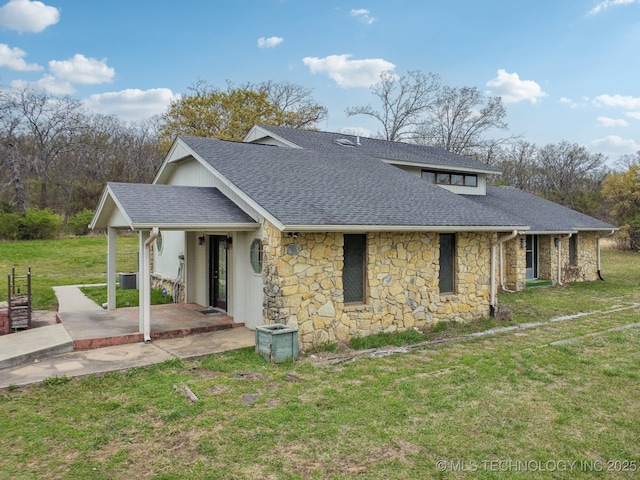 view of side of property with central AC, a shingled roof, a yard, a patio area, and stone siding
