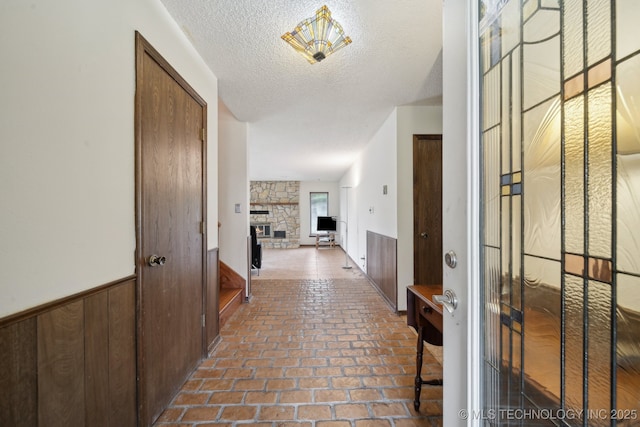 hallway with brick floor and a textured ceiling