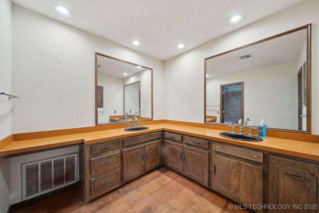 full bath featuring recessed lighting, visible vents, and wood finished floors