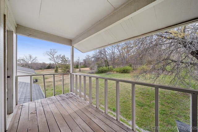 wooden deck featuring a lawn