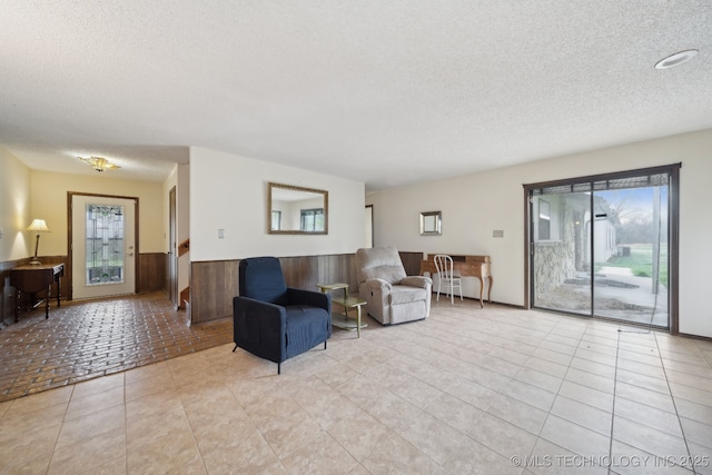 living area with a wainscoted wall and a textured ceiling