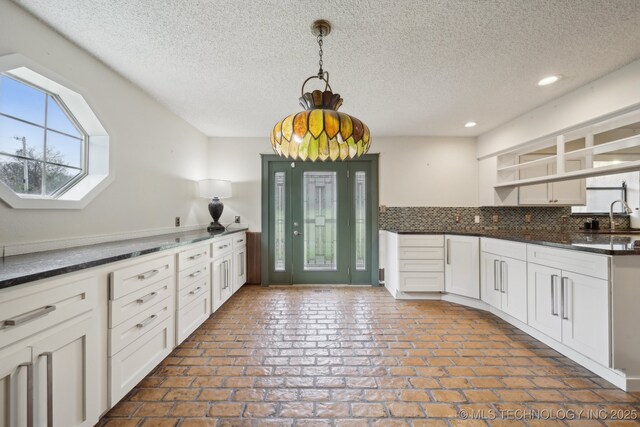 kitchen with open shelves, a textured ceiling, white cabinetry, recessed lighting, and decorative backsplash