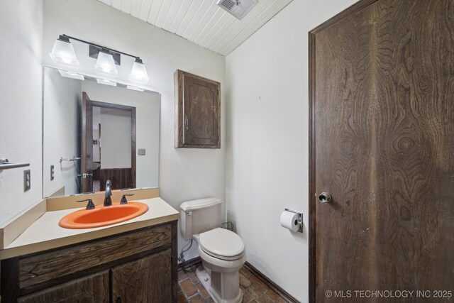 bathroom featuring vanity, visible vents, and toilet