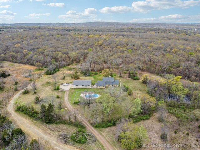 drone / aerial view featuring a wooded view