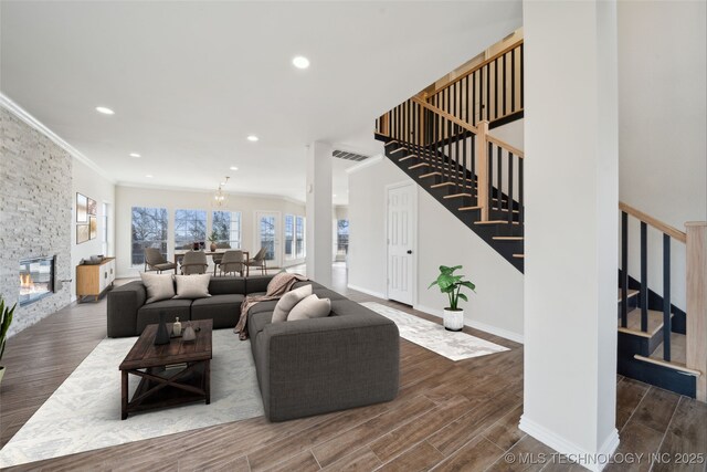 living room with crown molding and a fireplace