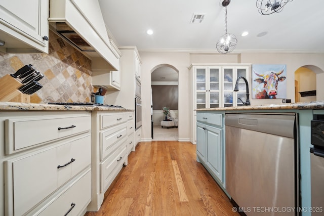 kitchen featuring white cabinetry, appliances with stainless steel finishes, backsplash, and crown molding