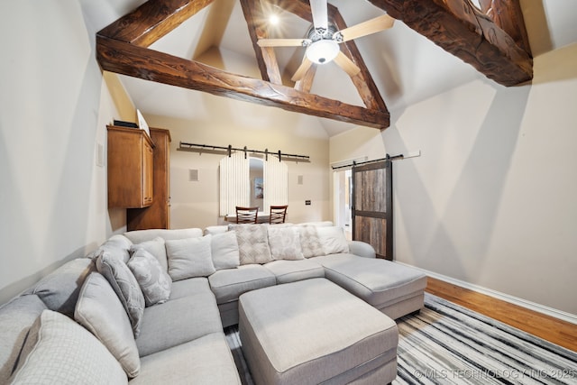 living room featuring beam ceiling, high vaulted ceiling, ceiling fan, a barn door, and light hardwood / wood-style floors