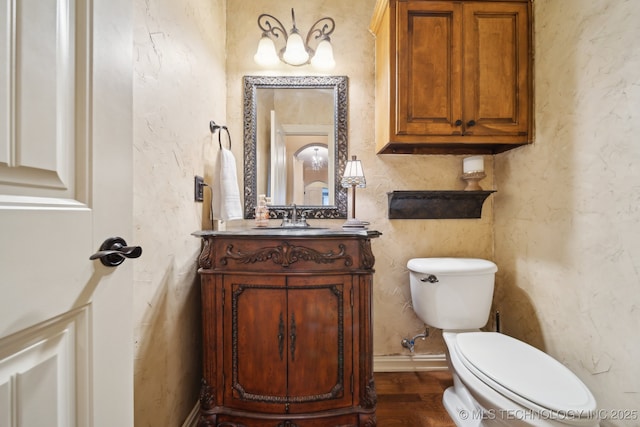 bathroom with vanity, toilet, and hardwood / wood-style floors