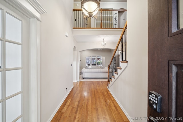 foyer entrance with crown molding and light hardwood / wood-style floors