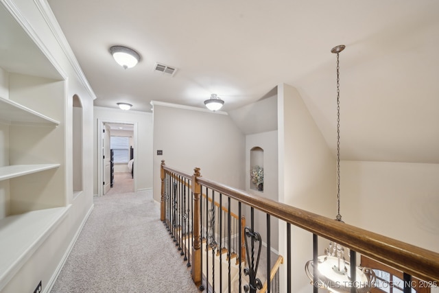 corridor featuring crown molding, light colored carpet, and vaulted ceiling