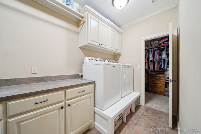 clothes washing area featuring cabinets, ornamental molding, separate washer and dryer, and light colored carpet