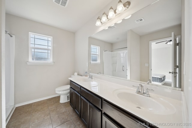 bathroom with tile patterned floors, vanity, toilet, and a shower