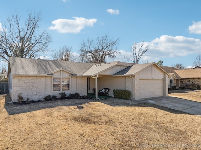 ranch-style home featuring a garage and a front lawn