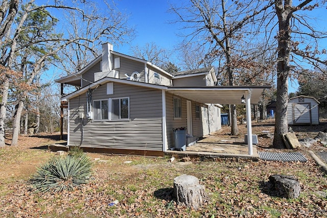 view of property exterior with a carport and a shed