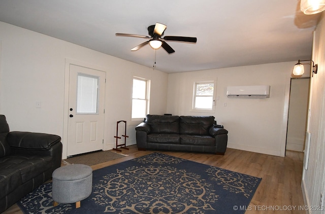 living room with hardwood / wood-style flooring, an AC wall unit, and ceiling fan