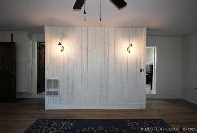 spare room featuring dark hardwood / wood-style floors, heating unit, and ceiling fan