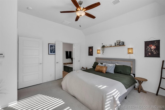 bedroom featuring ceiling fan, connected bathroom, vaulted ceiling, and light carpet