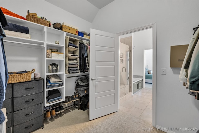 walk in closet with lofted ceiling and light carpet