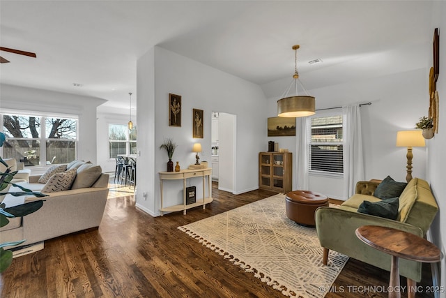 living room featuring ceiling fan, dark hardwood / wood-style floors, and vaulted ceiling