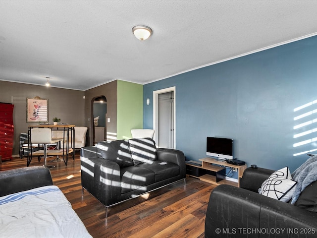 living room with dark wood-type flooring, ornamental molding, and a textured ceiling