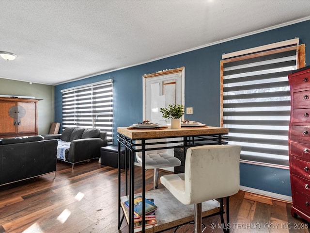 dining space with ornamental molding, dark hardwood / wood-style floors, and a textured ceiling