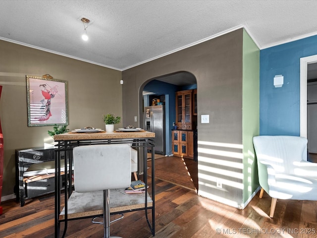 dining area with ornamental molding, dark hardwood / wood-style flooring, and a textured ceiling