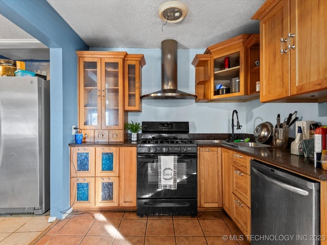 kitchen with appliances with stainless steel finishes, dark stone counters, tile patterned flooring, wall chimney range hood, and a textured ceiling