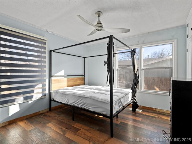 bedroom featuring ceiling fan, dark hardwood / wood-style floors, and a textured ceiling