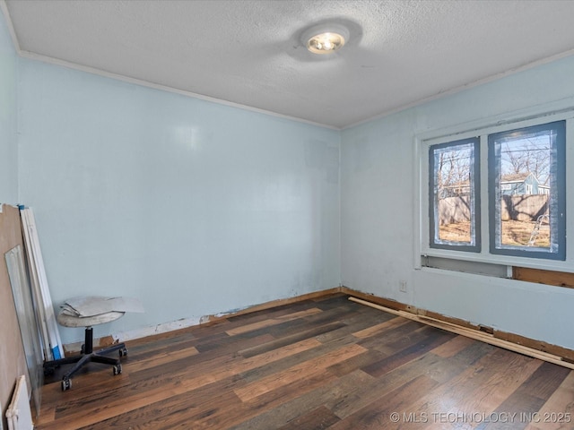 empty room with dark hardwood / wood-style floors and a textured ceiling