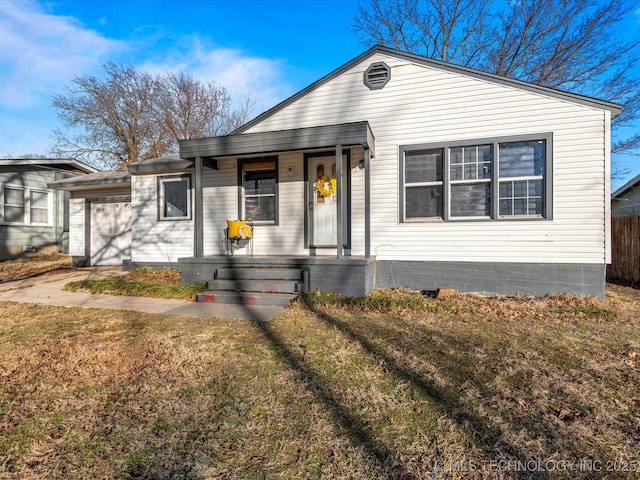 view of front of home featuring a garage, a front yard, and covered porch