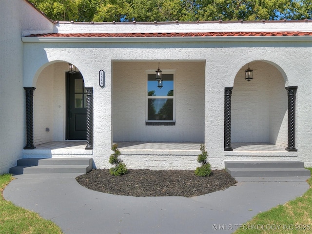 view of exterior entry with a porch